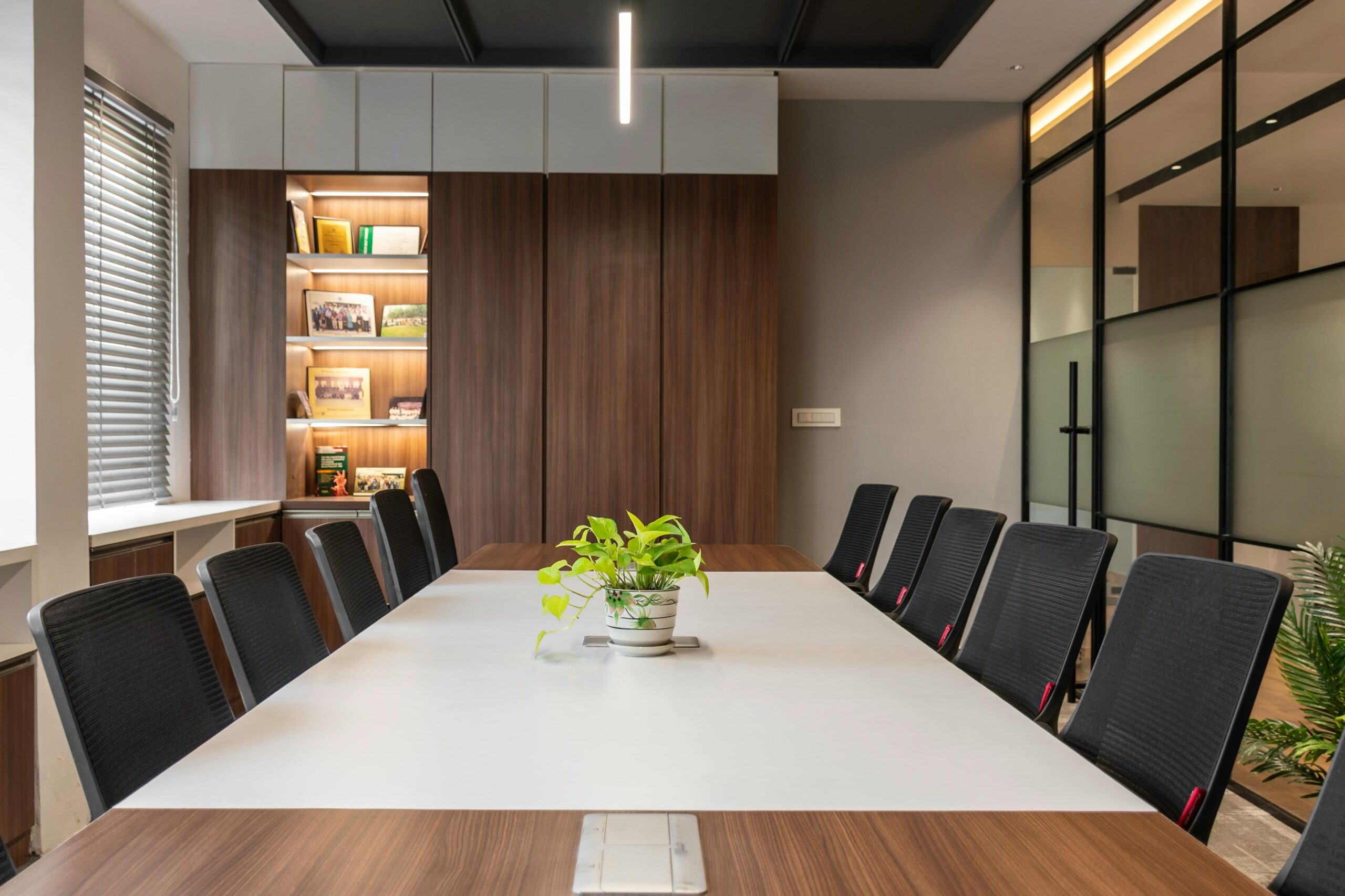 Stylish conference room with sleek design, office chairs, and indoor plants, ideal for corporate meetings.
