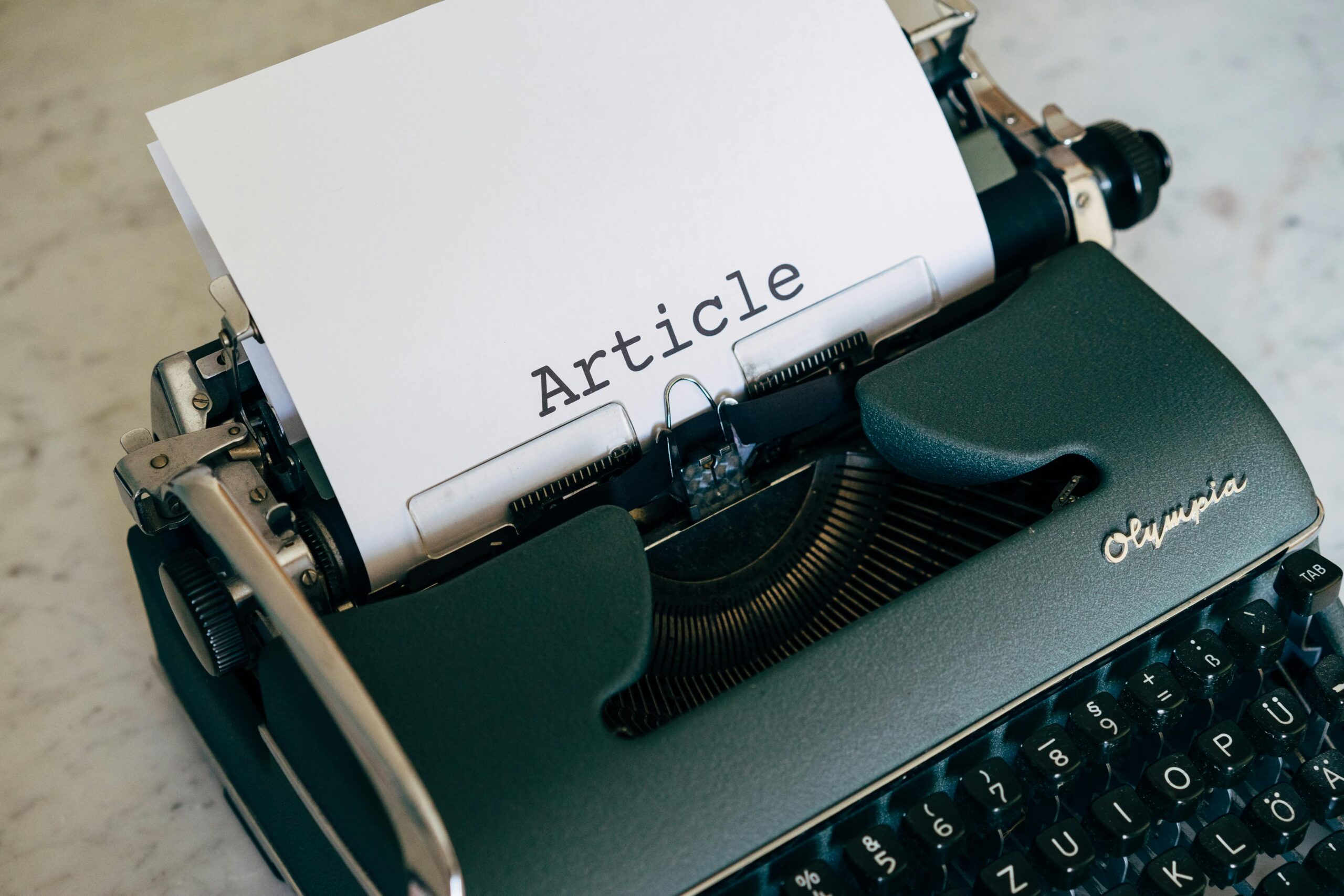 Close-up of a vintage typewriter with a paper sheet displaying 'Article' in retro font.