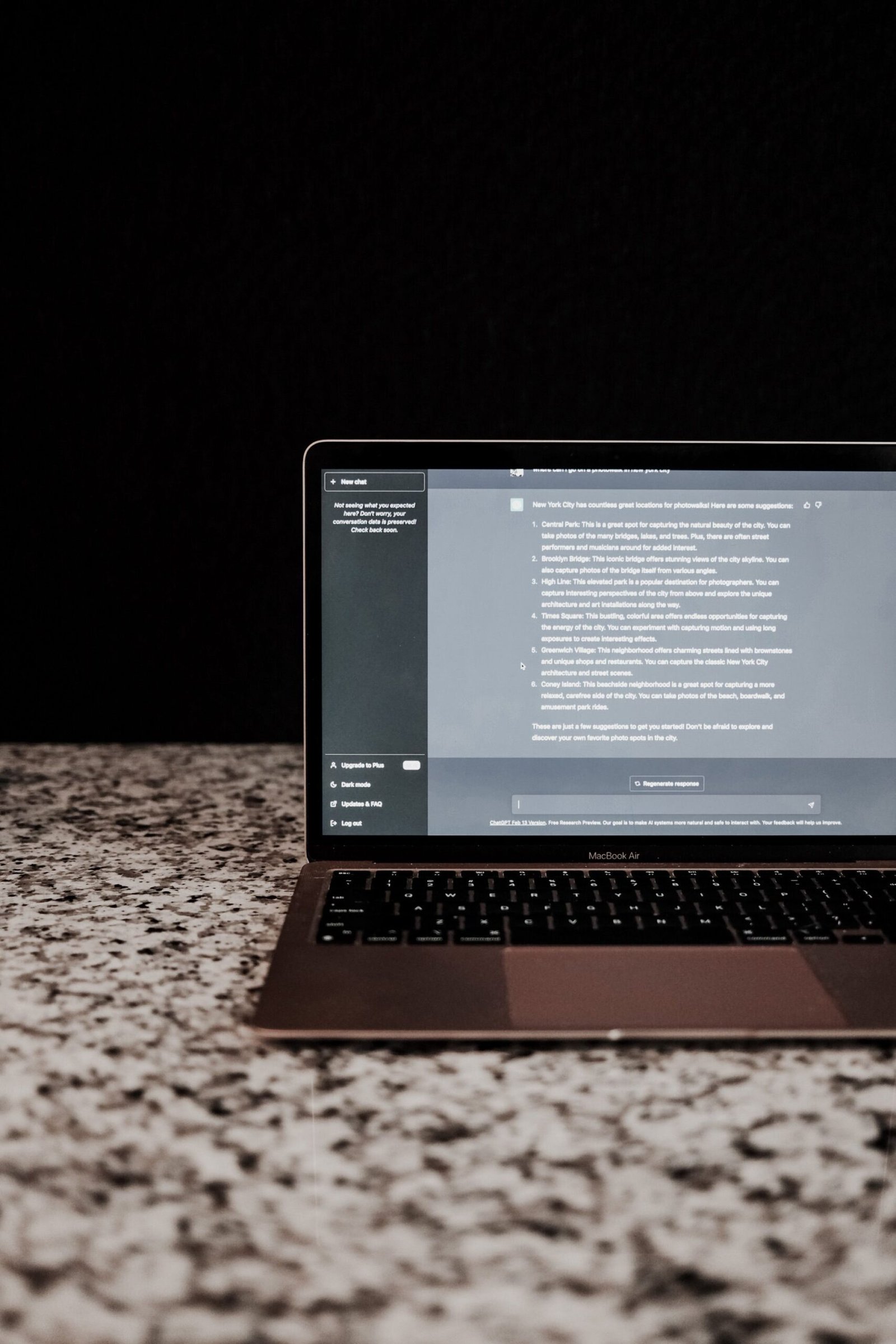 Modern laptop displayed on a granite countertop with a dark, minimalistic backdrop.