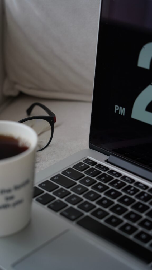 Cozy home office scene with coffee, laptop, and eyeglasses. Perfect for remote work inspiration.