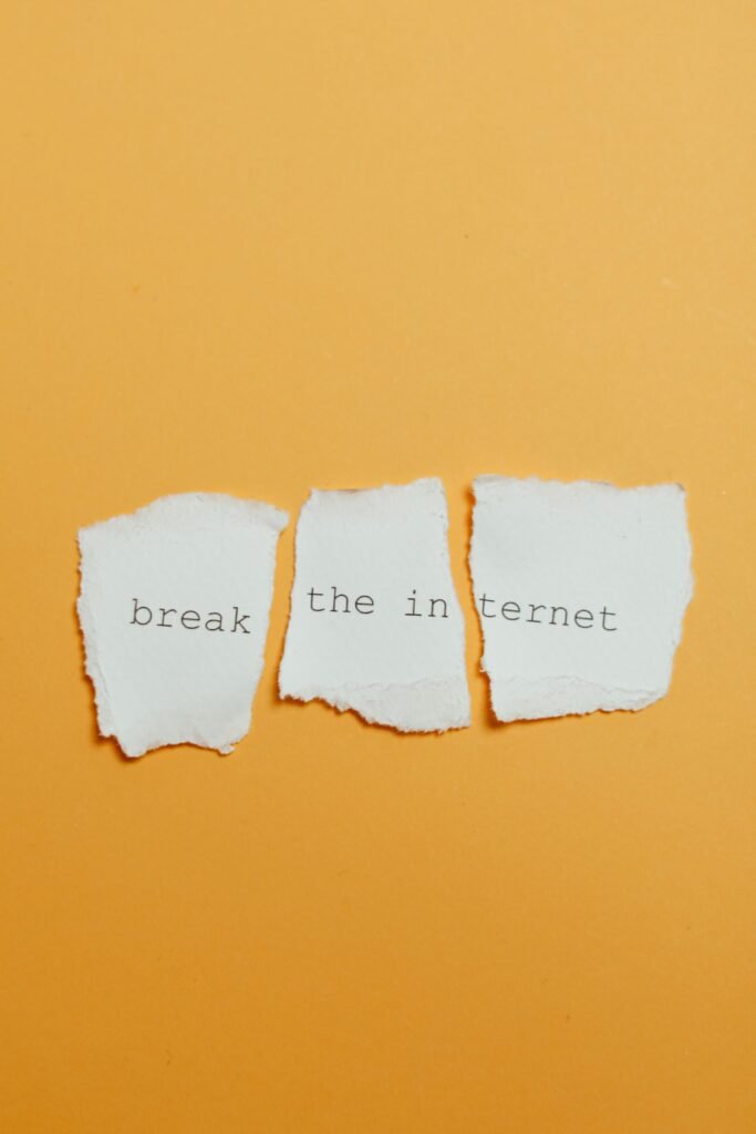 Conceptual image of torn paper with text 'break the internet' on yellow background.