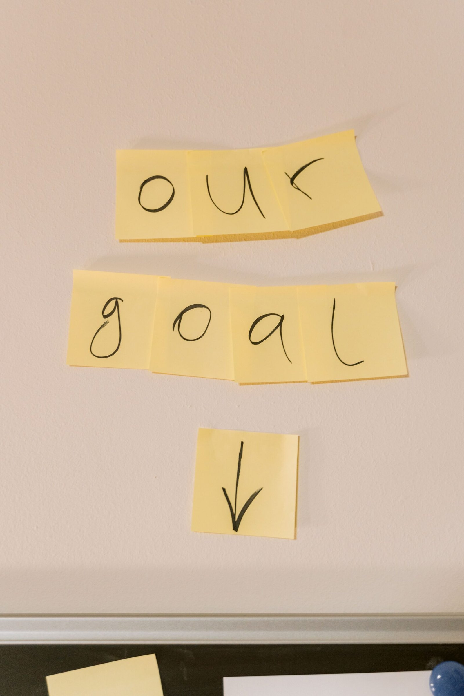 Sticky notes with the text 'our goal' on a wall emphasizing objectives.