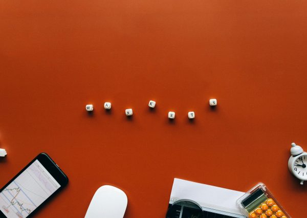 Creative still life with financial tools and the word 'MARKETS' on an orange background.