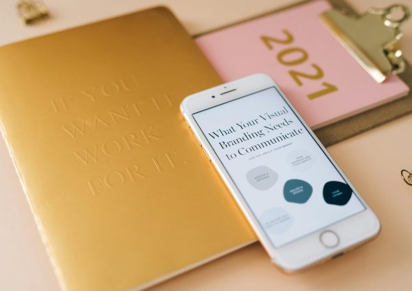 A smartphone and notebook on a desk for business planning and branding strategy.